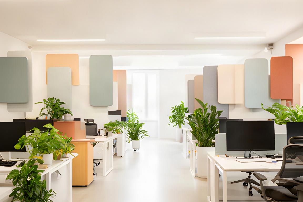 Ufficio contemporaneo nelle Marche con postazioni luminose, pannelli fonoassorbenti e verde