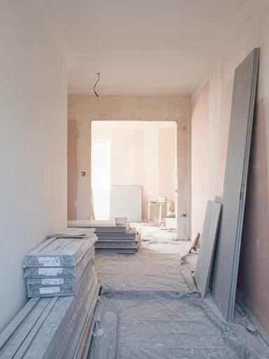Cantiere di rinnovamento d'interni con pareti in preparazione e materiali protetti