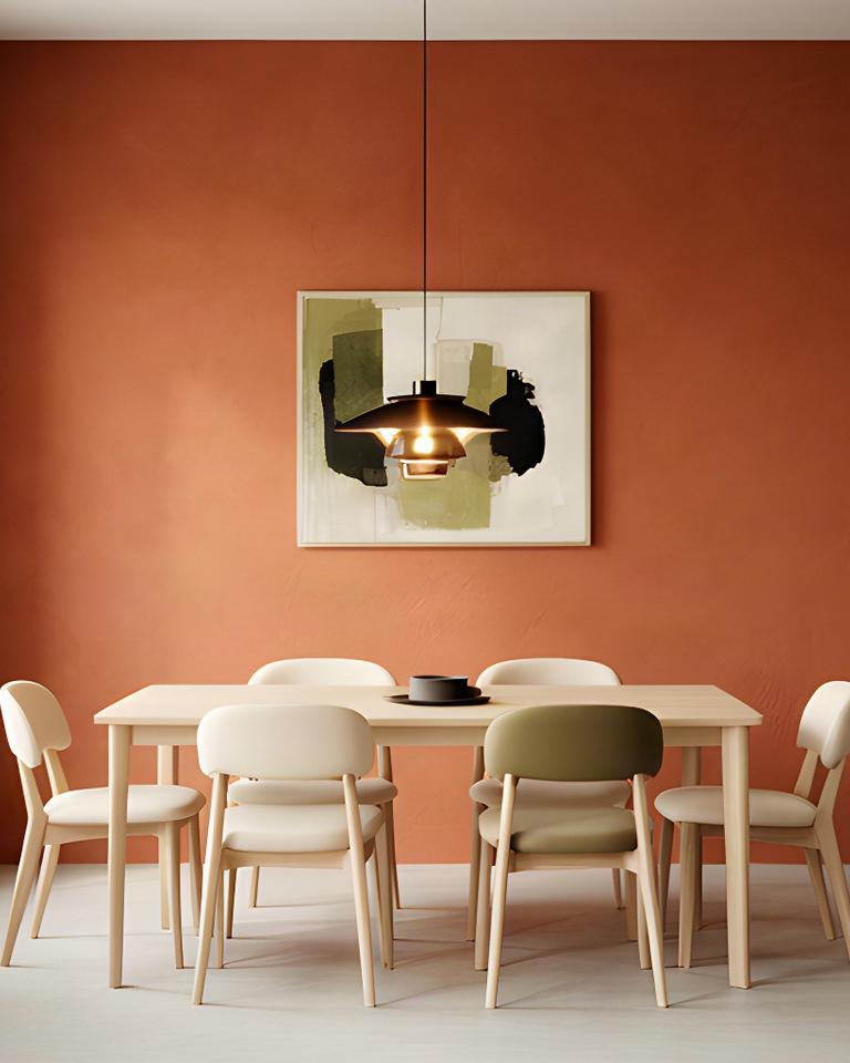 Parete d'accento color terracotta in una sala da pranzo con arredi chiari